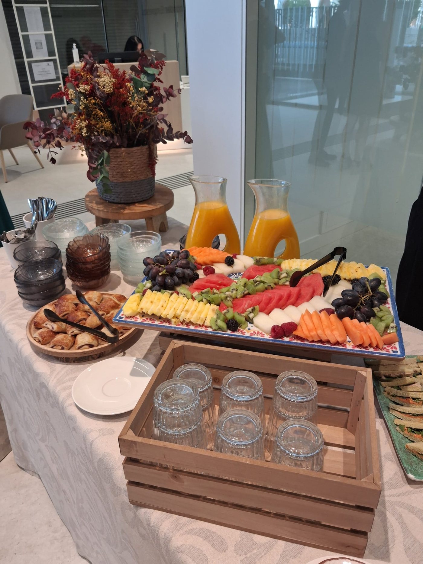 Mesa de catering con fruta, zumos y aperitivos